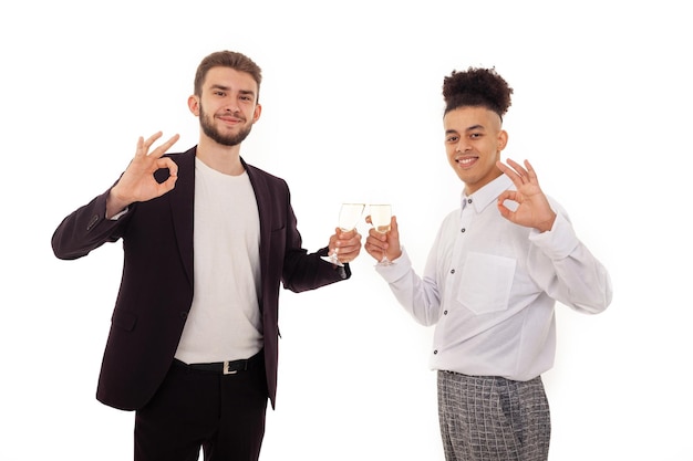 Caucasian man and American male friends in formal wear celebrating a birthday drinking champagne