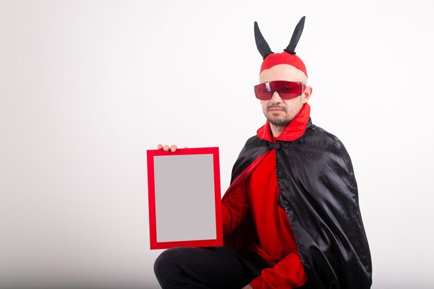 Caucasian man in halloween costume demonstrating empty nameplate