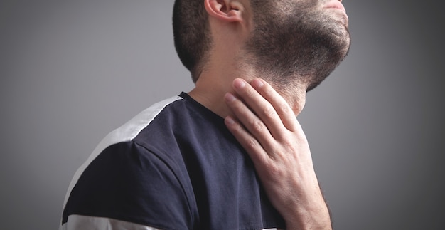 Caucasian man having throat pain.