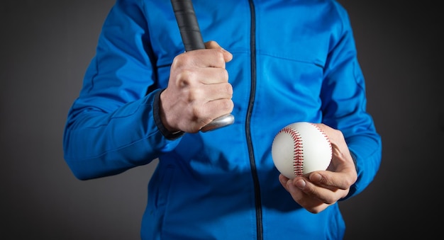 Caucasian man holding baseball bat and ball