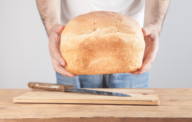 Caucasian man holding of bread over table.