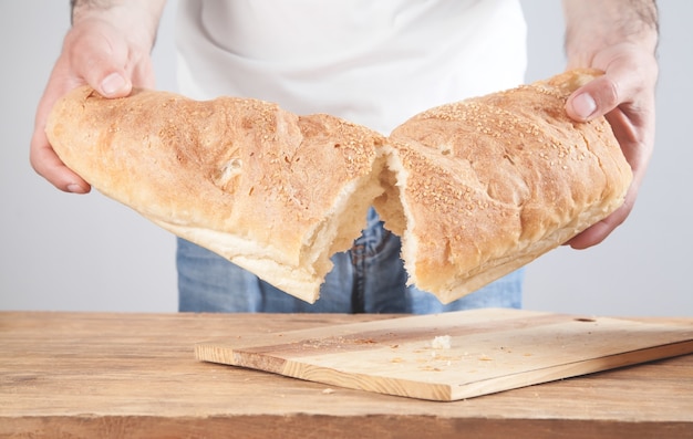 Caucasian man holding of bread over table.