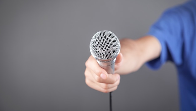 Caucasian man holding microphone in office.