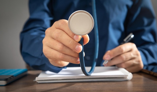 Caucasian man holding stethoscope at office