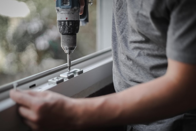 Caucasian man installs fittings for a window frame