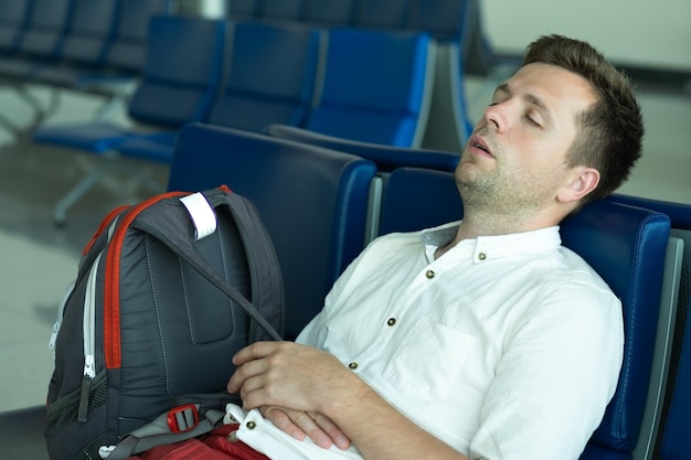 Caucasian man is sleeping in lounge area at the airport