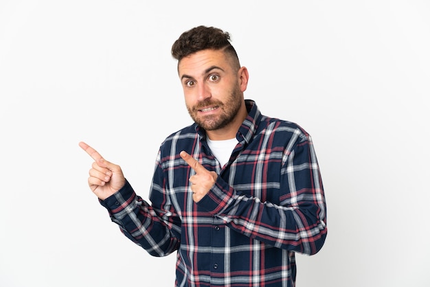 Caucasian man isolated on white background frightened and pointing to the side