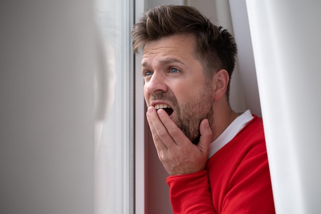 Caucasian man peeking through window being shocked with accident on street