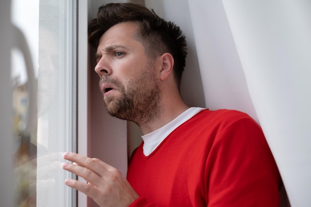 Caucasian man peeking through window being shocked with accident on street