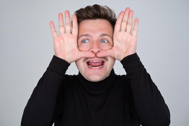 Caucasian man showing big mustache with hands