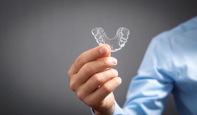 Caucasian man showing transparent aligner