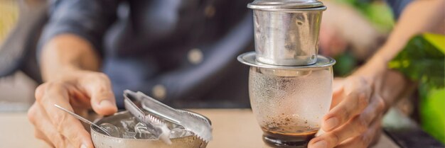 Caucasian man and traditional drip brewed vietnamese coffee from a phin filter banner long format