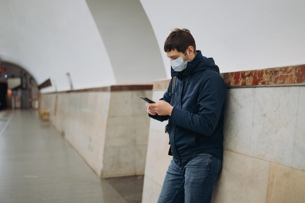 Caucasian man wearing medicine mask going to get in subway car on platform of underground station in saint petersburg Russia Image with selective focus