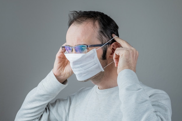 Caucasian man wearing a white medical mask for protection against contagious disease, coronavirus