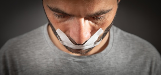 Caucasian man with tape on mouth Censorship