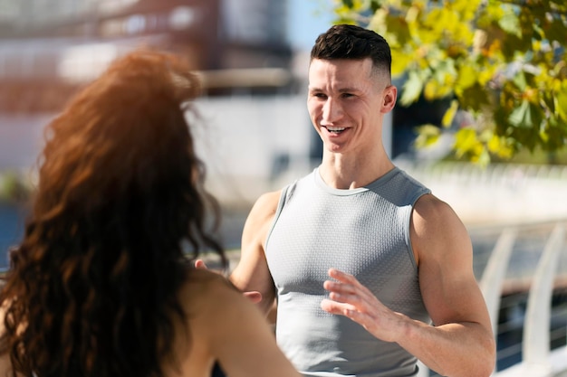 Caucasian man and woman sportive couple speaking together at street