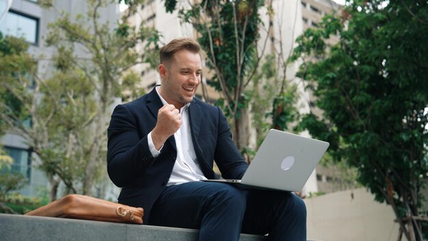 Caucasian manager working on laptop and celebrate successful project Urbane