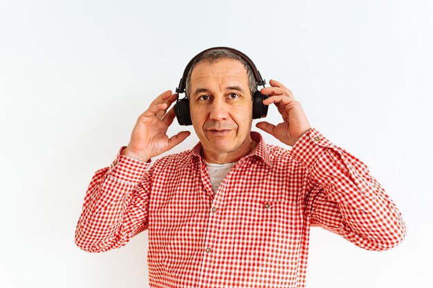 Caucasian middle aged man smiling while listening to music with headphones, enjoying music