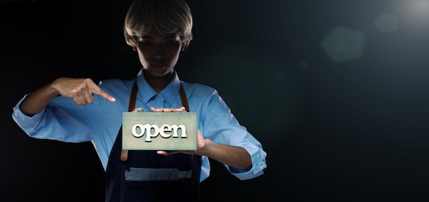 Photo caucasian person hold open sign business to show service at door entrance store cafe retail and welcome shop happy entrepreneur female blonde hair wear waitress dress as open business time concept