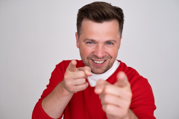 Caucasian positive guy pointing two forefingers front to the camera