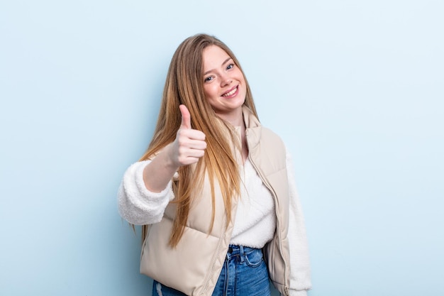 Caucasian red hair woman feeling proud, carefree, confident and happy, smiling positively with thumbs up