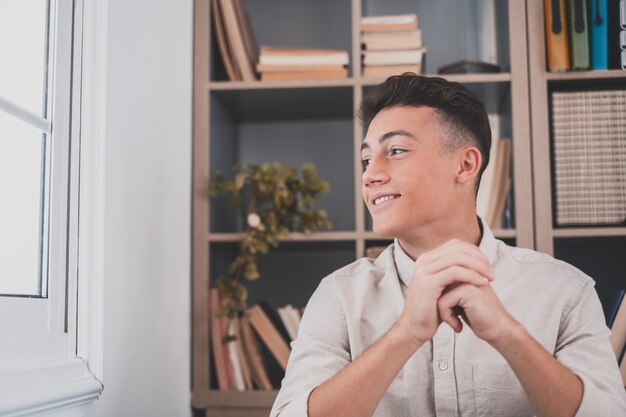 Caucasian reflexive looking at laptop screen, reflexing on work, businessman independent working in a difficult project. Male teenager preparing at home in the office indoor.