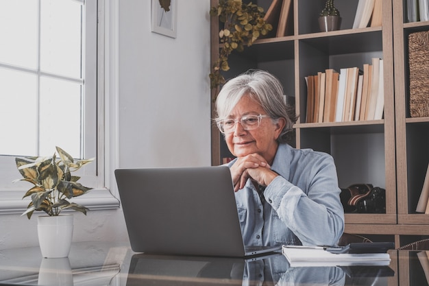 Caucasian reflexive looking at laptop screen, reflexing on work, businesswoman independent working in a difficult project. Female person preparing at home in the office indoor.