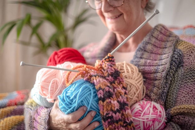 Caucasian senior woman at home holding in her hands wool balls ready for knitting Hobby retirement relax concept for elderly female grandmother enjoying hand made work