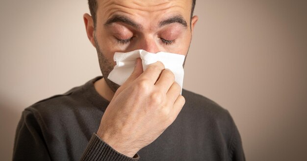 Caucasian sick man blowing his nose