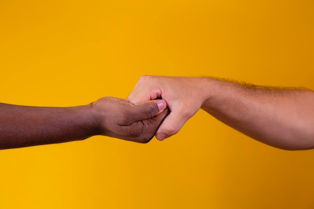 Caucasian woman and African American man holding hands together in backlight racism concept