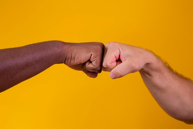 Caucasian woman and African American man holding hands together in backlight racism concept