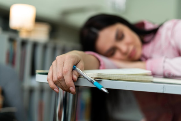 Caucasian woman got tired of working and studying next to the stack of papers and books Work and study concept