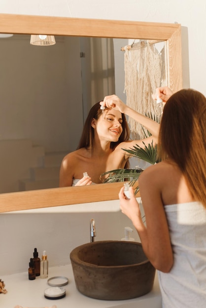 Caucasian Woman Holding Bottle With Moisturising Face Serum Ready To Make Beauty Treatment After Shower Skin Care Products