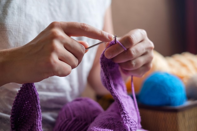 Caucasian woman knits woolen clothes Holding knitting needles at hands