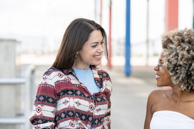 Caucasian woman looking at her African American girlfriend, multi-ethnic, couple of beautiful women