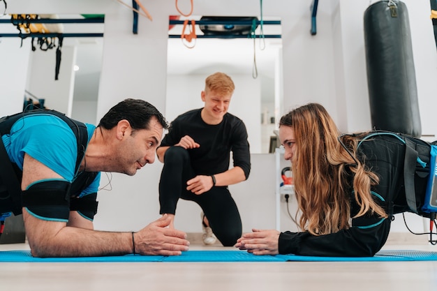 Caucasian woman and a middle-aged man doing planks while high-fiving