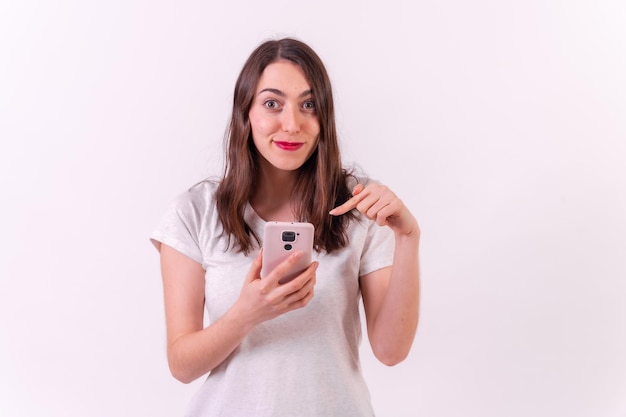 Caucasian woman pointing to a phone isolated on a white background technology concept