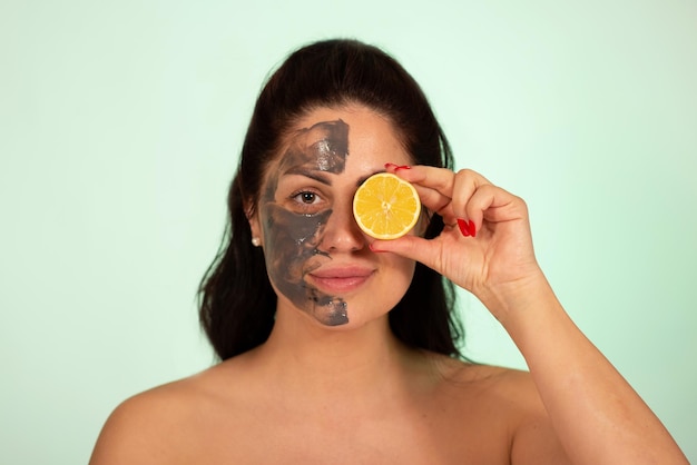 Caucasian woman portrait in 30 40 ages with clay face mask with lemon vitamin C