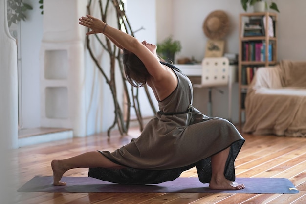 Caucasian woman practicing yoga doing warrior pose variation