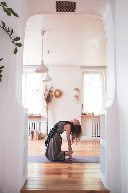 Caucasian woman practicing yoga lesson doing ushtrasana or camel pose