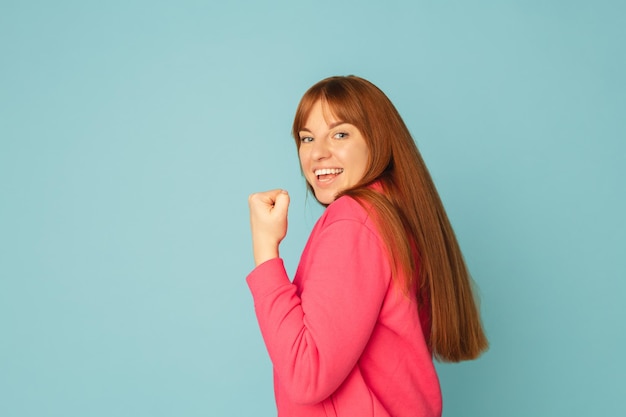 Caucasian woman's portrait isolated on blue studio background with copyspace