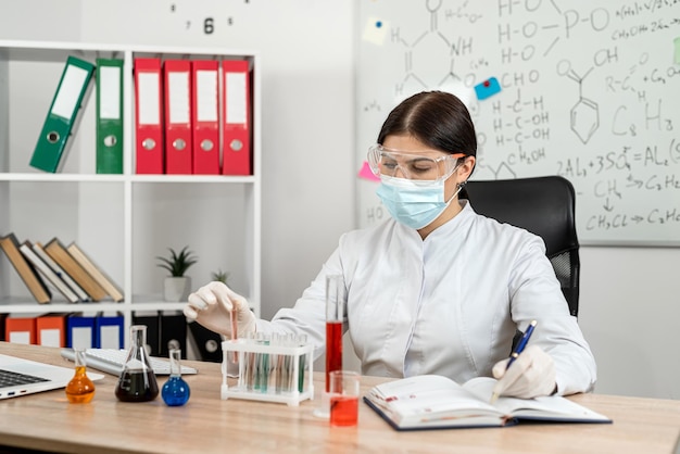 caucasian woman scientist mixed liquid from flask into beaker