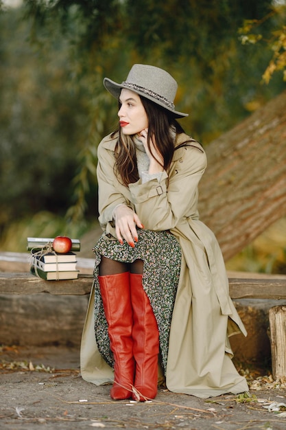 Caucasian woman sitting on a wooden bench with books