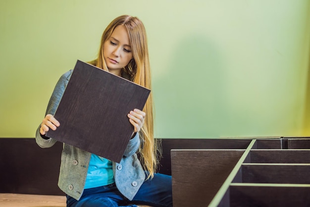 Caucasian woman using screwdriver for assembling furniture