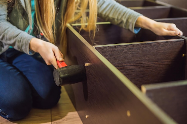 Caucasian woman using screwdriver for assembling furniture