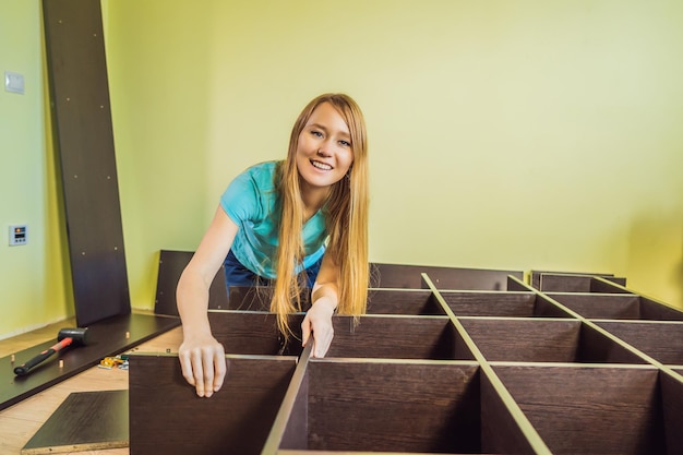 Caucasian woman using screwdriver for assembling furniture