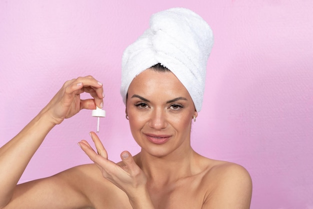 Caucasian woman using skin care serum with pipette anti ageing concept