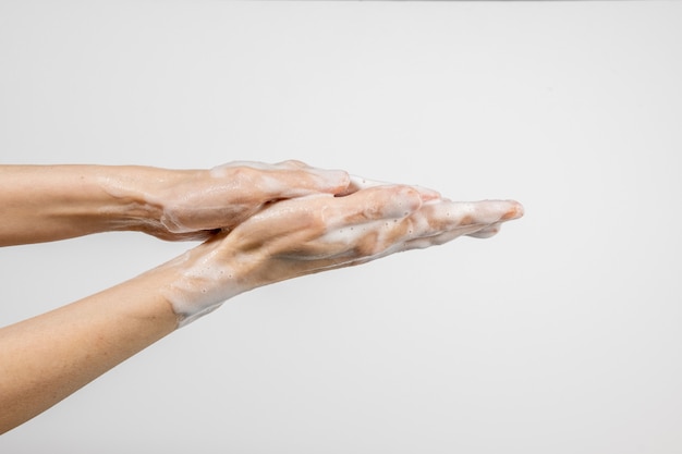 Caucasian woman washing her hands isolated on white wall