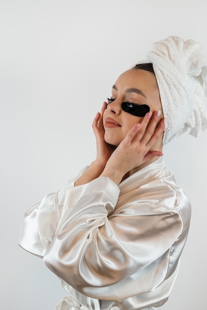 Caucasian woman in whie towel with collagen patch on face skincare