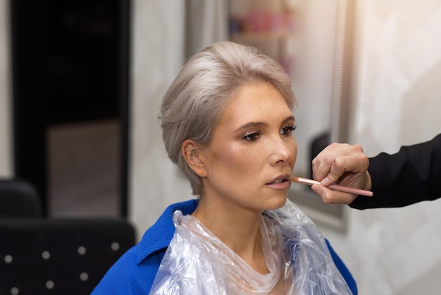 caucasian woman with short haircut on makeup at specialist